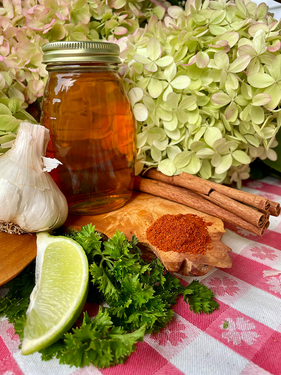 jar of honey on a table with infused honey ingredients